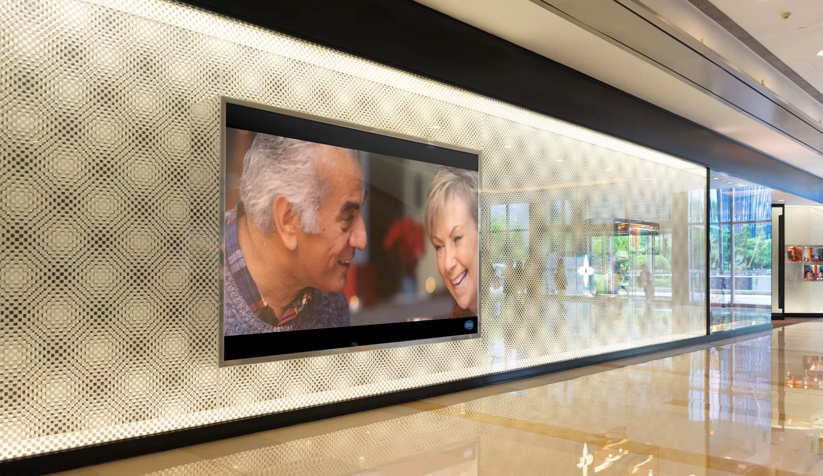 Hidden Hearing campaign photography — Life Is Worth Hearing film playing on a screen in a Hidden Hearing office
