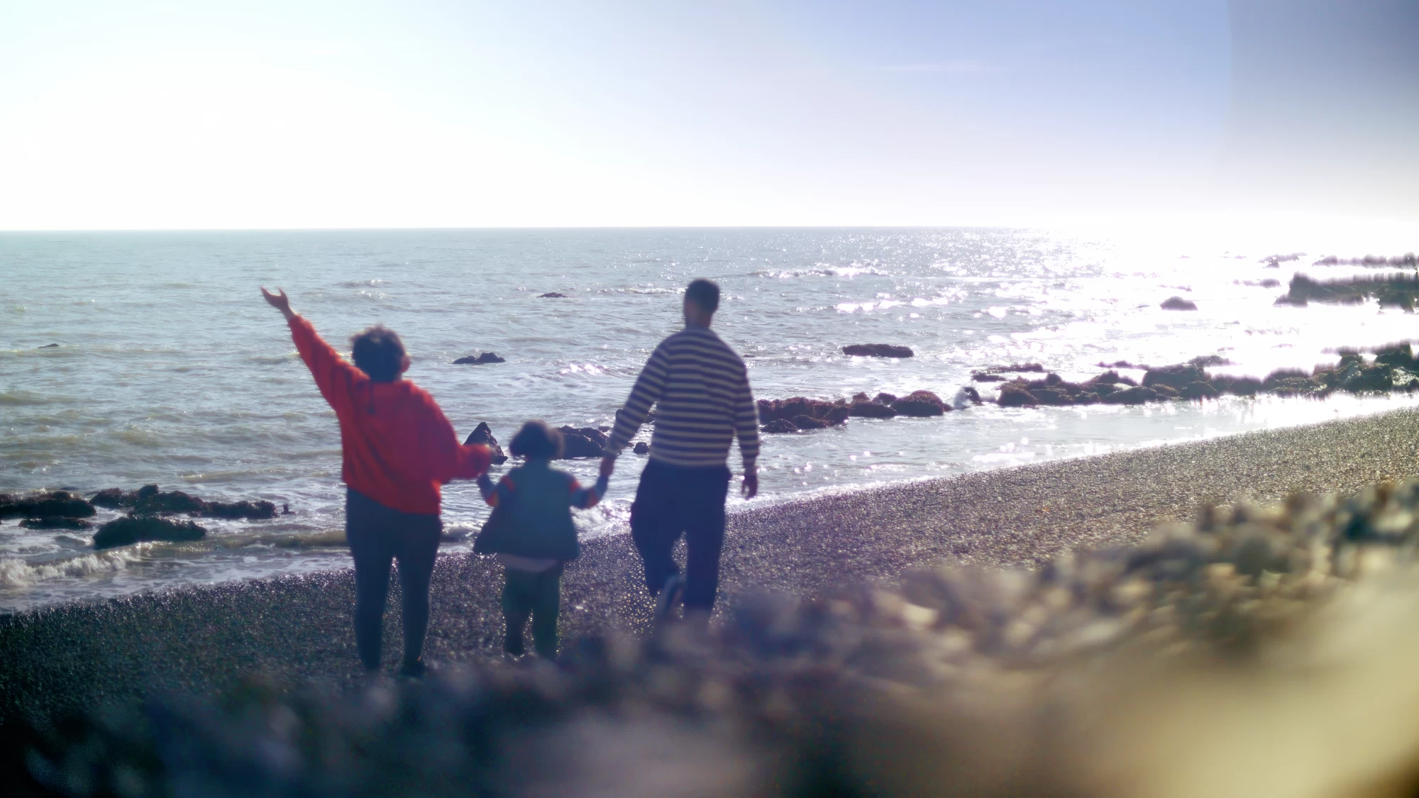 Visit Kent tourism photography — parent and child on the beach at sunset, waving out to sea