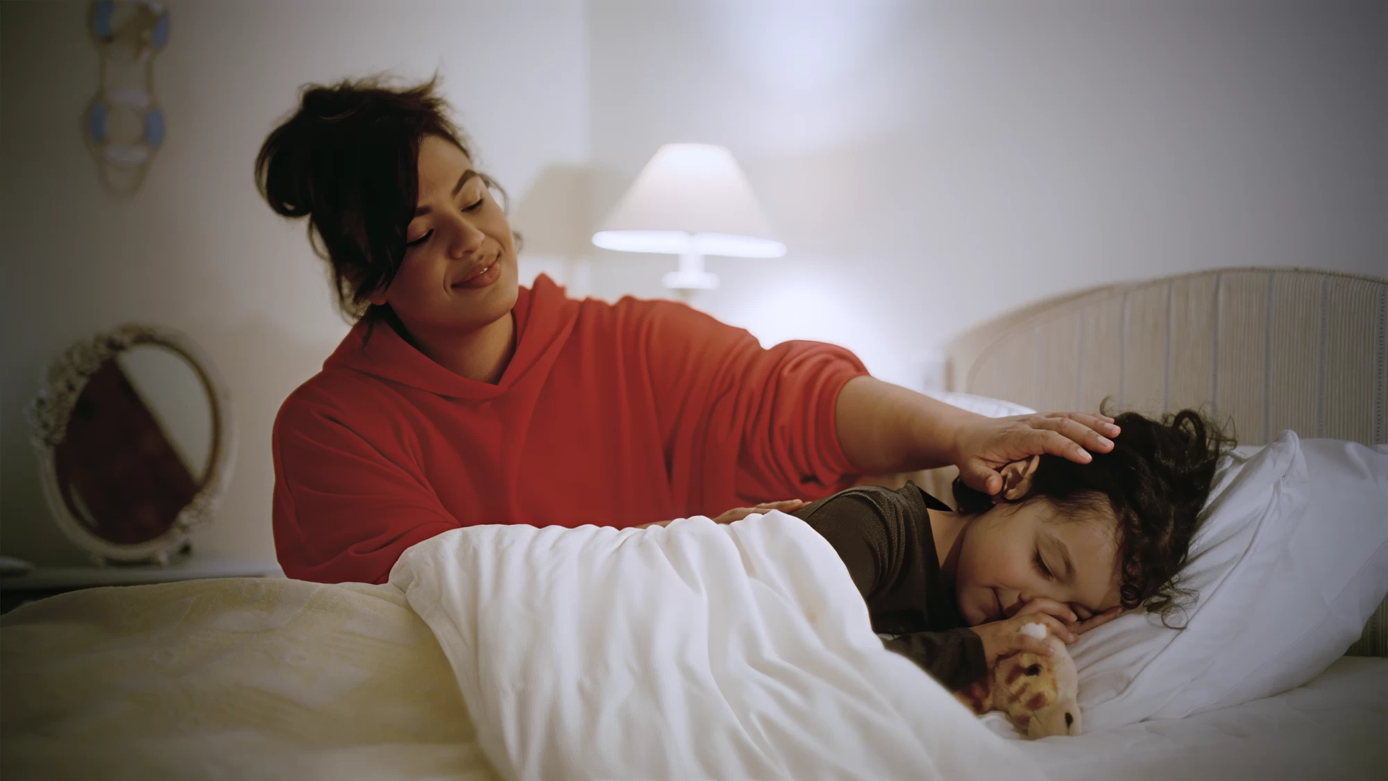 Visit Kent tourism photography — parent tucking a sleeping child into bed