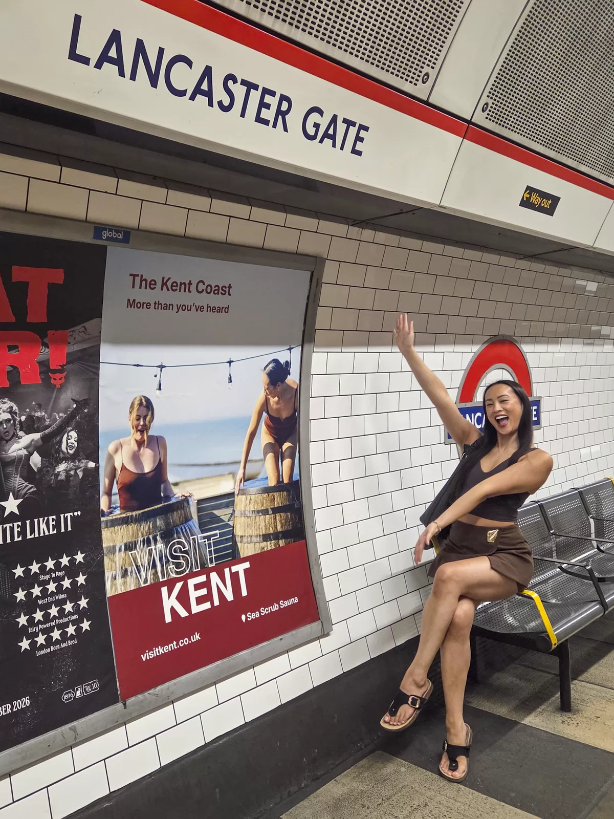 Visit Kent campaign model Selina Chiu posing beside a Visit Kent poster at Lancaster Gate Underground station