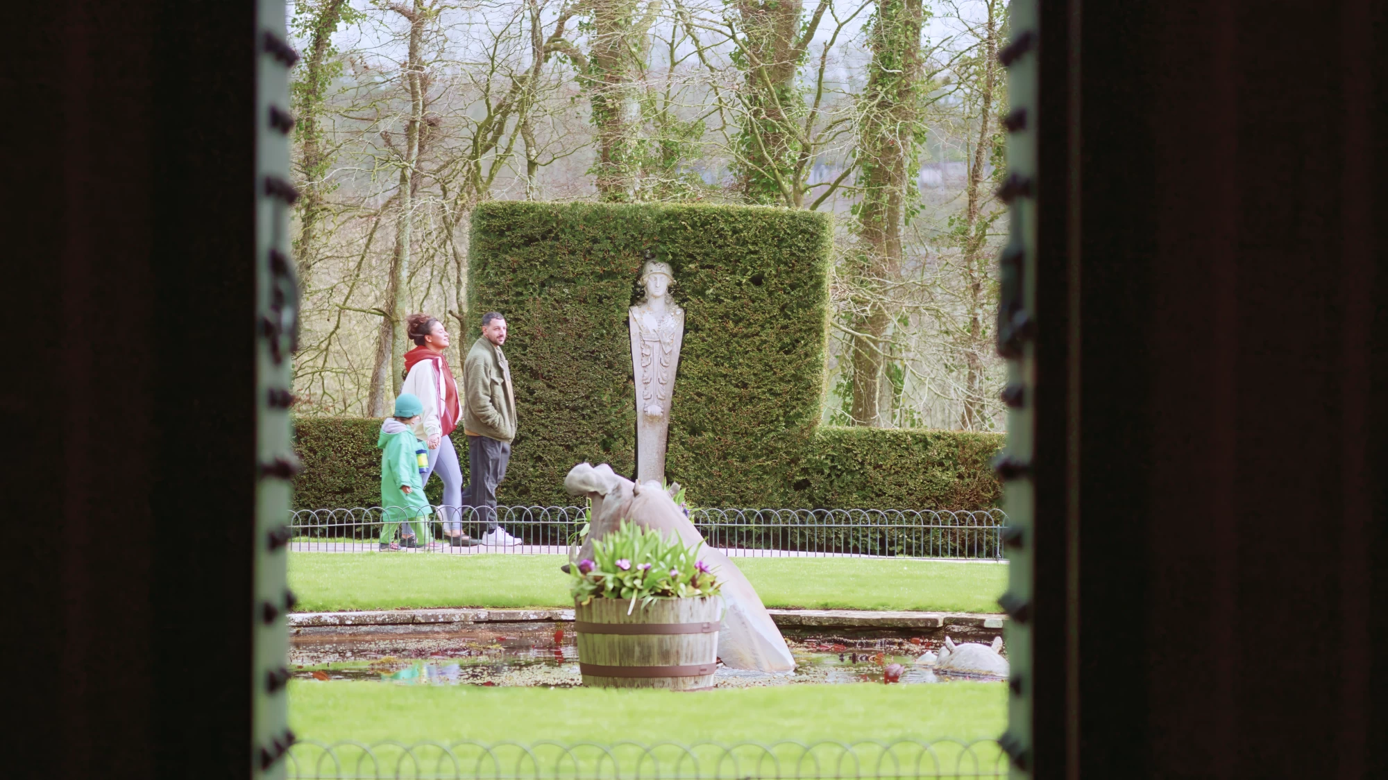 Visit Kent tourism photography — family exploring a historic garden with statue and topiary hedge