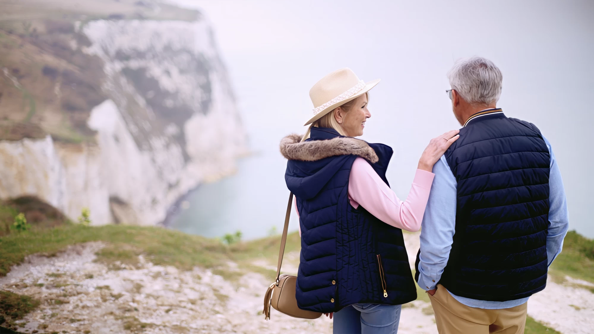 Visit Kent tourism photography — empty-nester couple walking the pebble beach beneath the White Cliffs